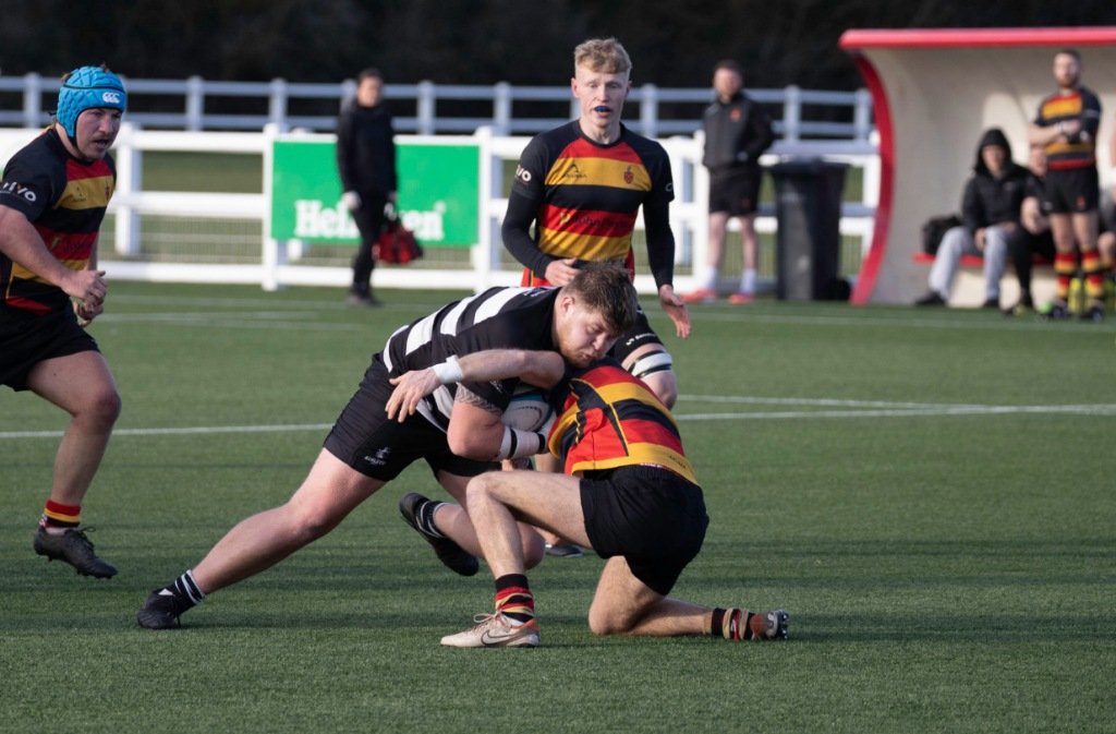 A Bedford Athletic rugby player crashes into a tackle from an Old Coventrians opponent