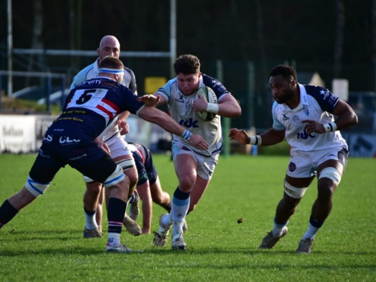Joey Conway of Bedford Blues runs into a tackle from a Doncaster player at Castle Park
