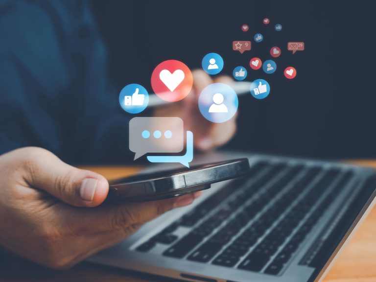 Mobile phone and laptop with social media icons Image Anucha Tiemsom Shutterstock