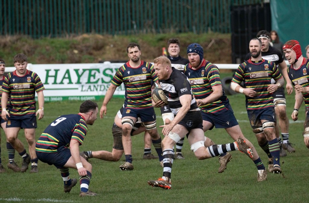 A Bedford Athletic rugby player runs into a tackle at Northampton Old Scouts