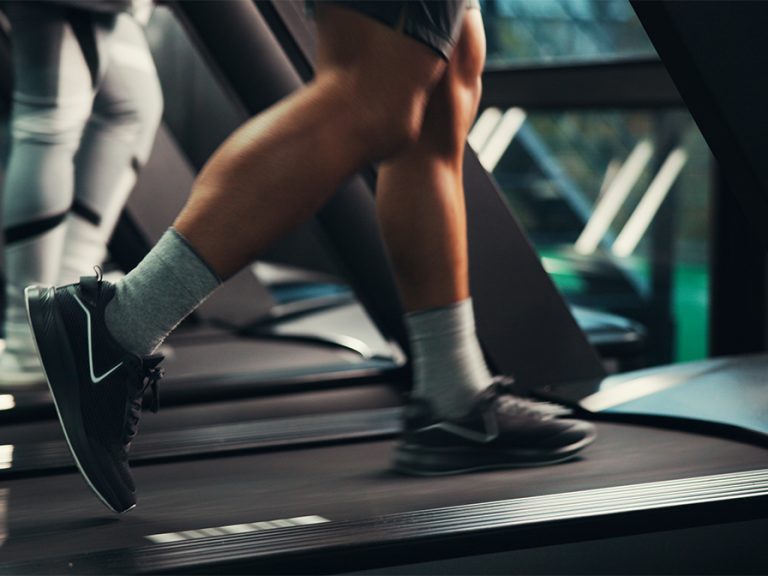 close up of persons legs on treadmill running machine