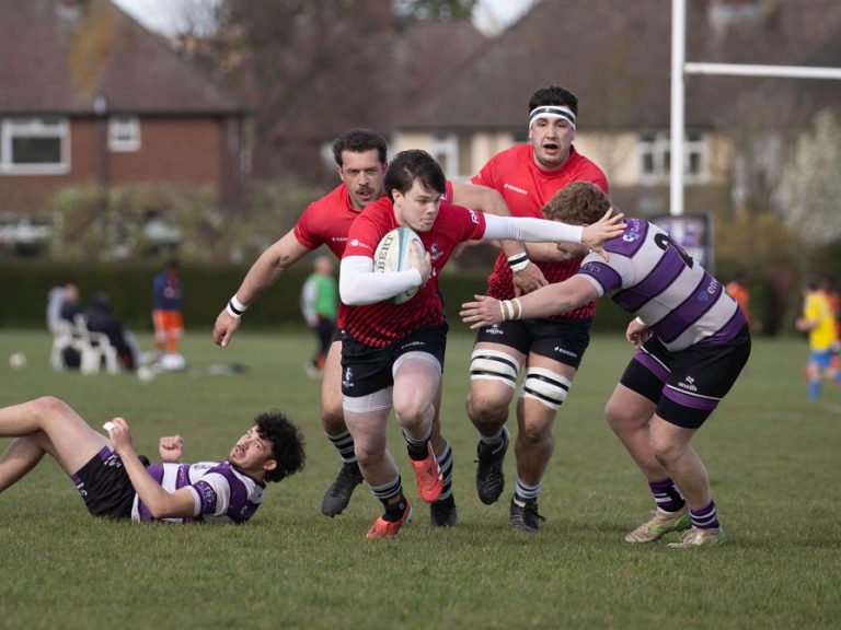 A Bedford Athletic rugby player holds off a tackle against Stamford in April 2026