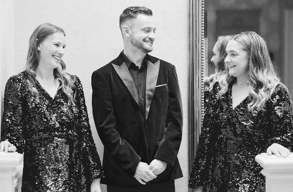 Black and white photo of the three members of the Capella singing group