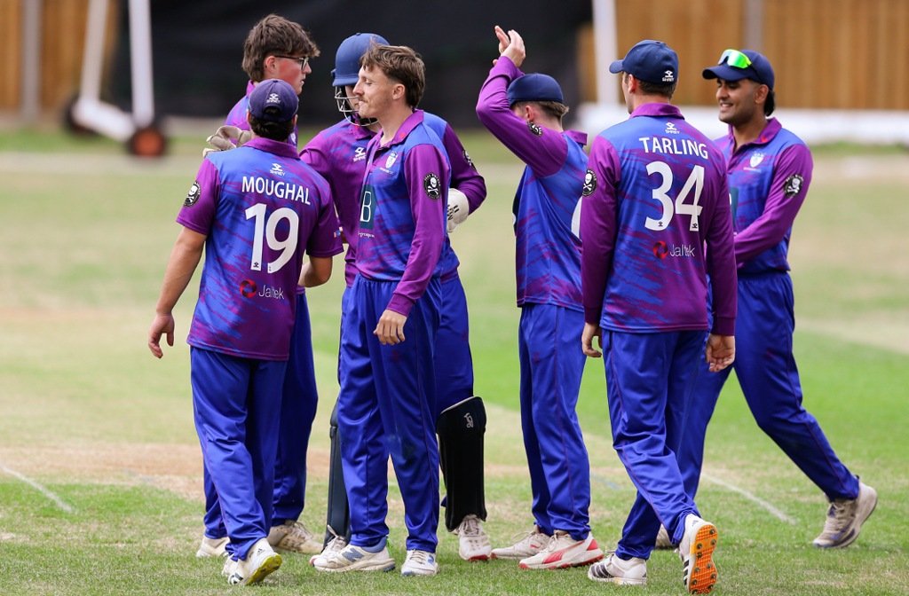 A group of seven Bedfordshire cricketers giving each other high fives after taking a wicket in the cricket