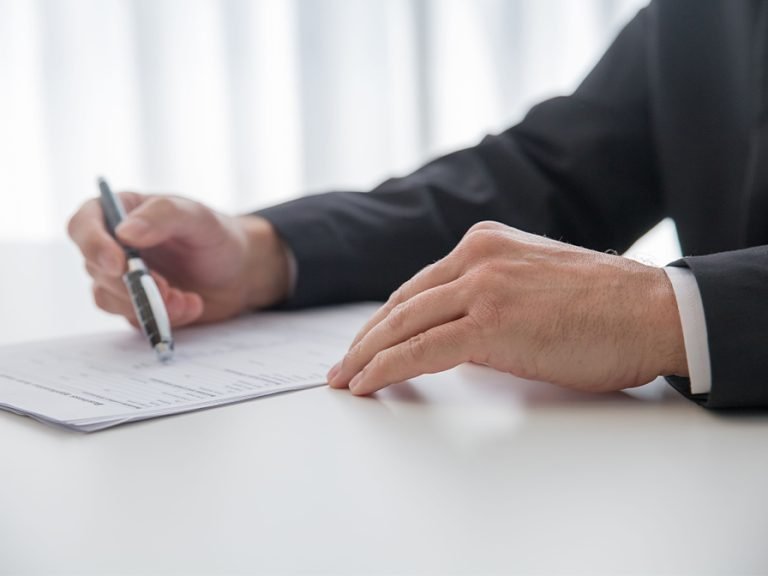 Businessman signing important documents at office desk. Image Kampus Production Pexels