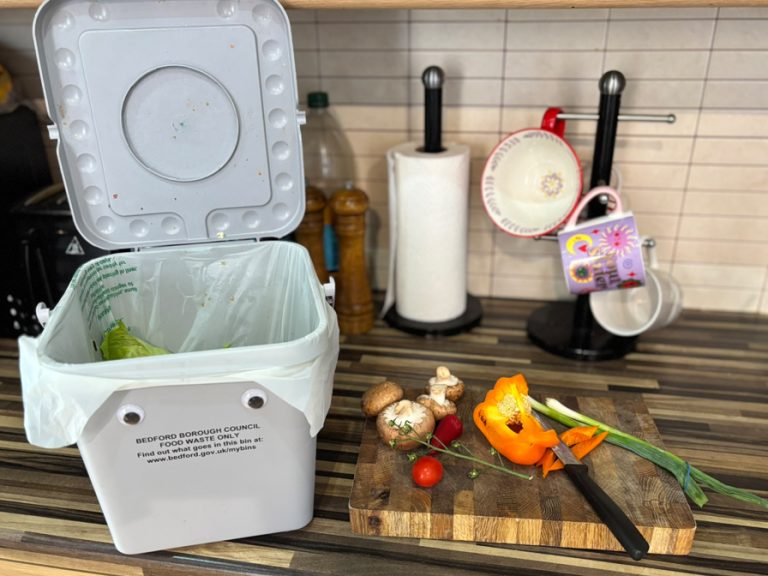 Food waste and the food waste caddy on a kitchen worktop