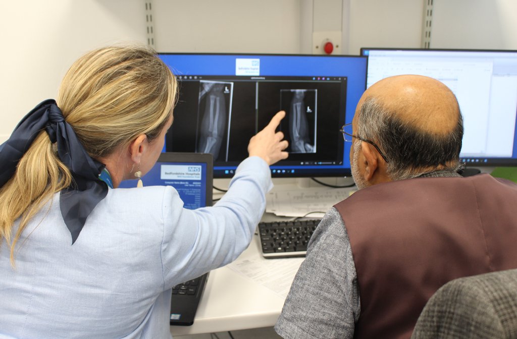 Lucy Orme, Specialist Physiotherapist and Mr Sundararajan, Orthopaedic Consultant analysing an X-ray film at Bedfordshire's Virtual Fracture Clinic