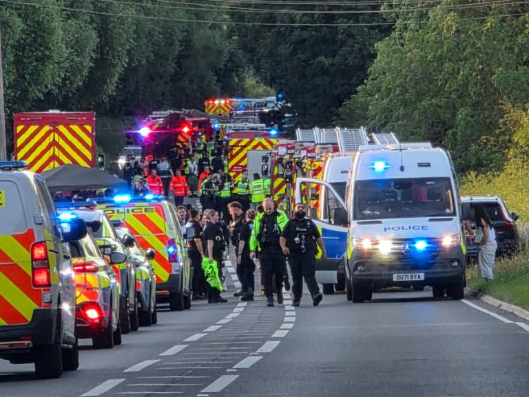 Ambulances, fire engines and emergency service personnel lined up along a road near to where the train collision occurred on 19 June 2026. Image: RRT