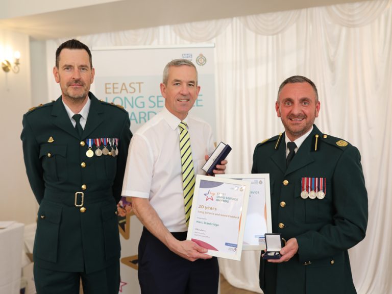 (l-r) EEAST Chief Operating Officer Darren Meads, CEO Neill Moloney, present Marc Stanbridge, Head of Clinical Operations for Bedfordshire and Luton, with a 20-year Ambulance Service Long Service and Good Conduct Medal and an award for 25 years' NHS service. Image: EEAST.