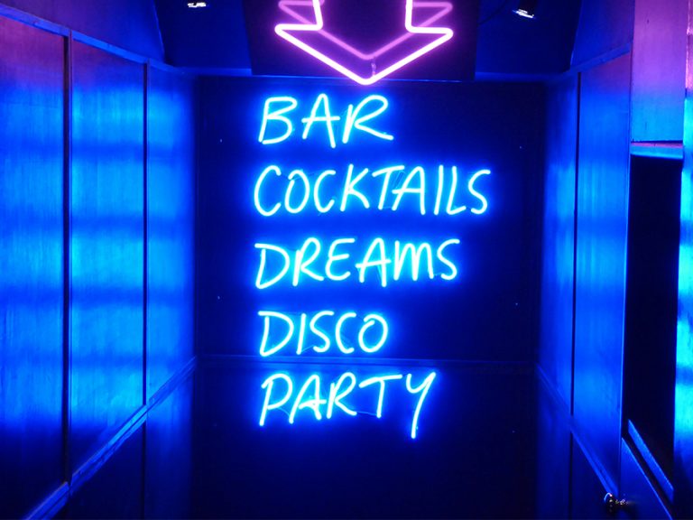A neon sign at a nighclub entrance which say bar, cocktails, dreams, disco, party Image Nick Fewings unsplash