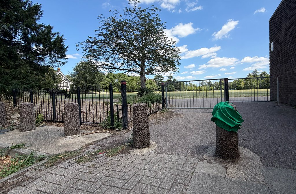 A pair of green shorts left on a concrete bollard at the entrance to Bedford Park next to Robinson Pool