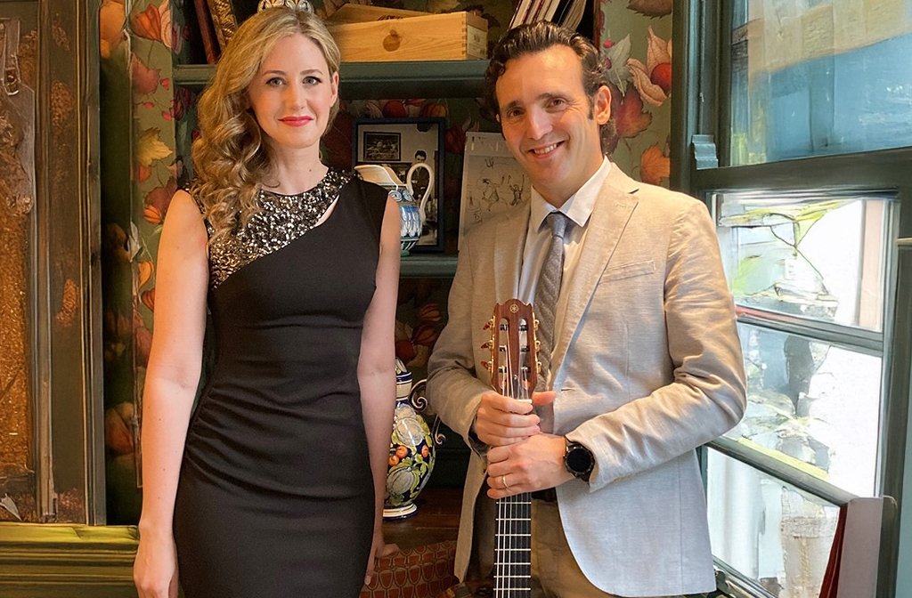 Giorgio Serci holding a guitar alongside singer Hetty Loxston