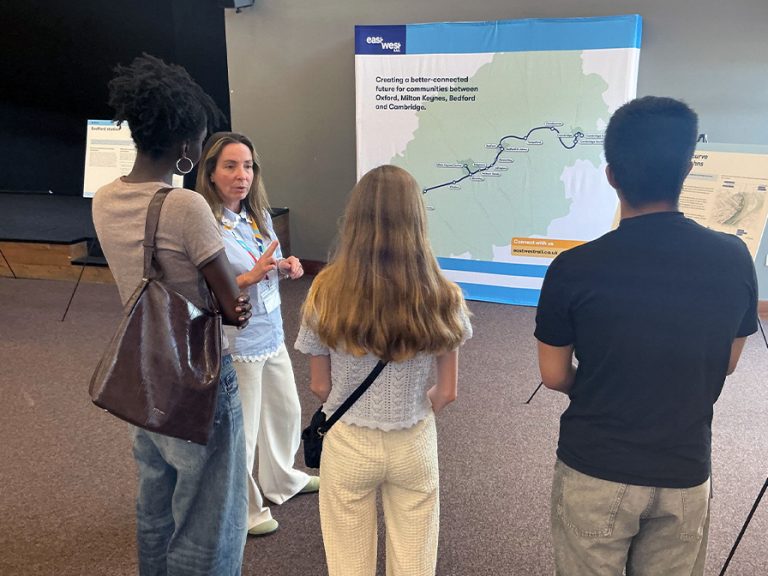 Members of the Bedford Youth Cabinet speaking to an EWR Co. spokesperson in front of a display board about the prokect. Image: EWR Co.
