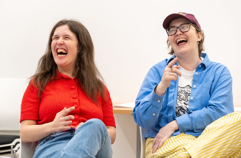 Rosie Jones and Aisling O'Connor CEO of the Rose Jones Foundation sitting on a sofa and laughing heartily. Image The Rosie Jones Foundation
