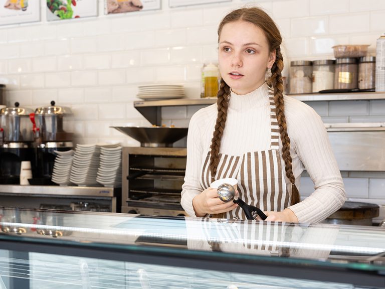 Teenage girl working behind the counter part-time in an ice cream parlour. Image: BearFotos /Shutterstock.