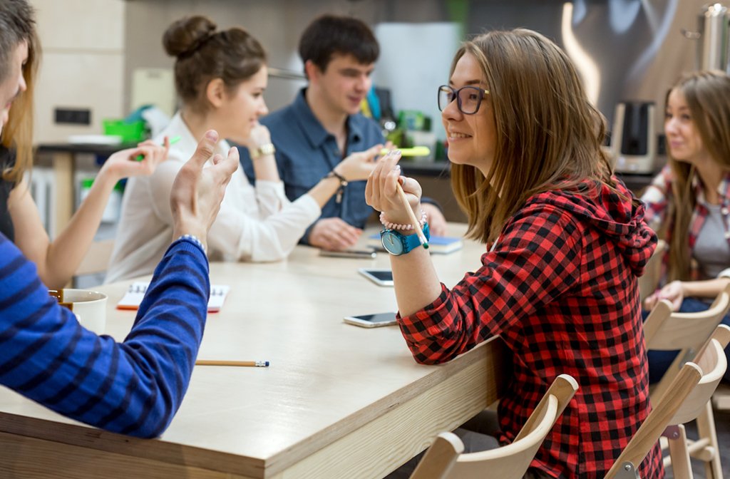 Young people around a table playing a game at a youth club.