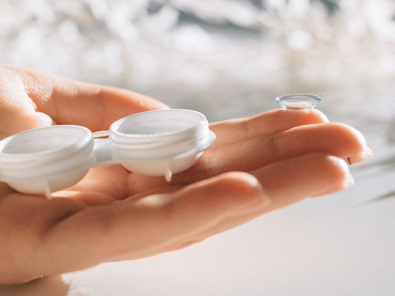 A hand delicately holds a contact lens and case against a blurred background Image Nataliya Vaitkevich Pexels