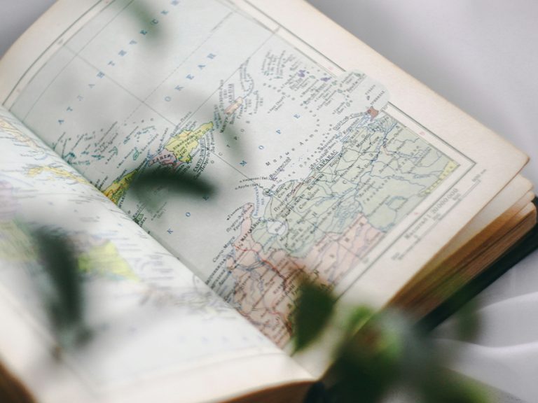 A travel, book open on a page showing a map Image pure julia Unsplash
