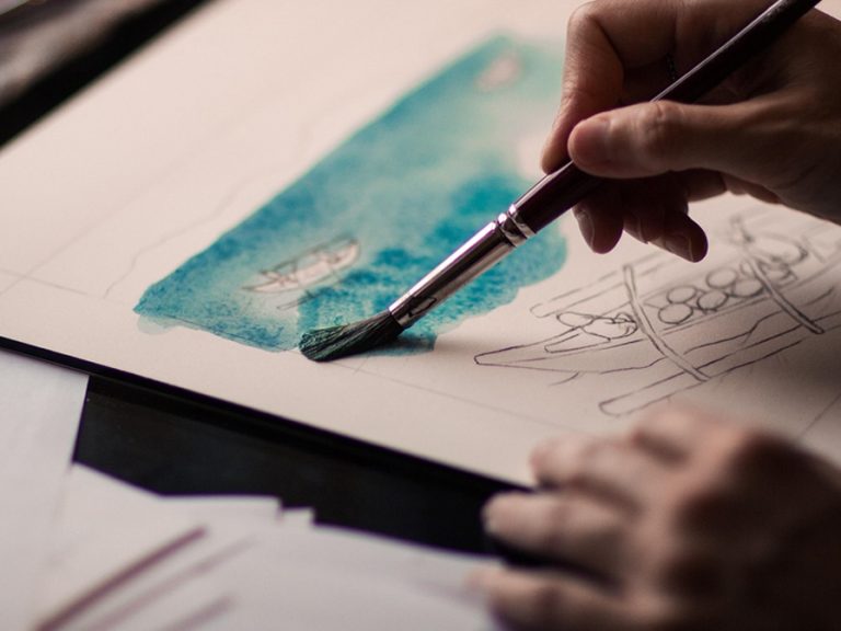 A watercolour artist painting a seascape. Image Pexels