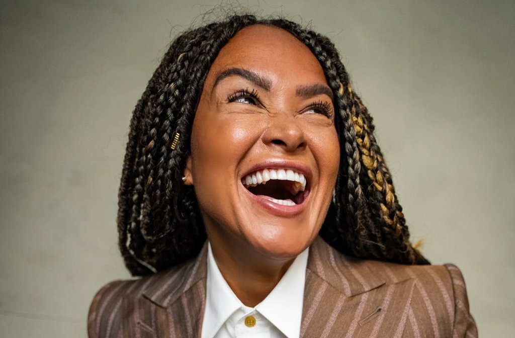 Singer, DJ and performer Zoe Birkett laughing in a smart pinstripe suit