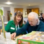 Carers in Bedfordshire volunteer helping an older man with a jigsaw puzzle. Image Carers in Bedfordshire