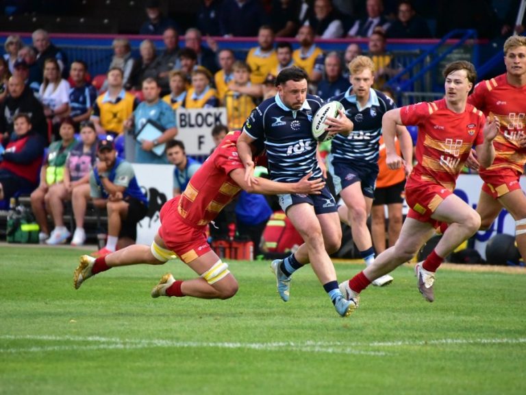 James Lennon of Bedford Blues attempts to break away from a Cambridge tackle in a pre-season friendly at Goldington Road